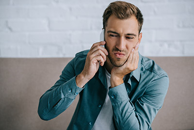 man calling an emergency dentist in Simi Valley, CA because of tooth pain